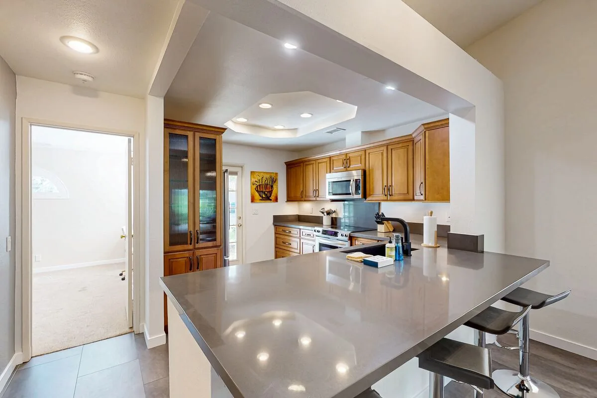 A bright kitchen with wooden cabinets and a large island.