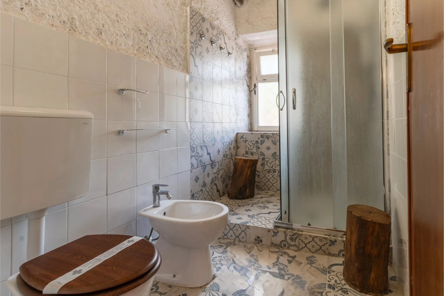 Un baño con azulejos, inodoro, lavabo y ducha.
