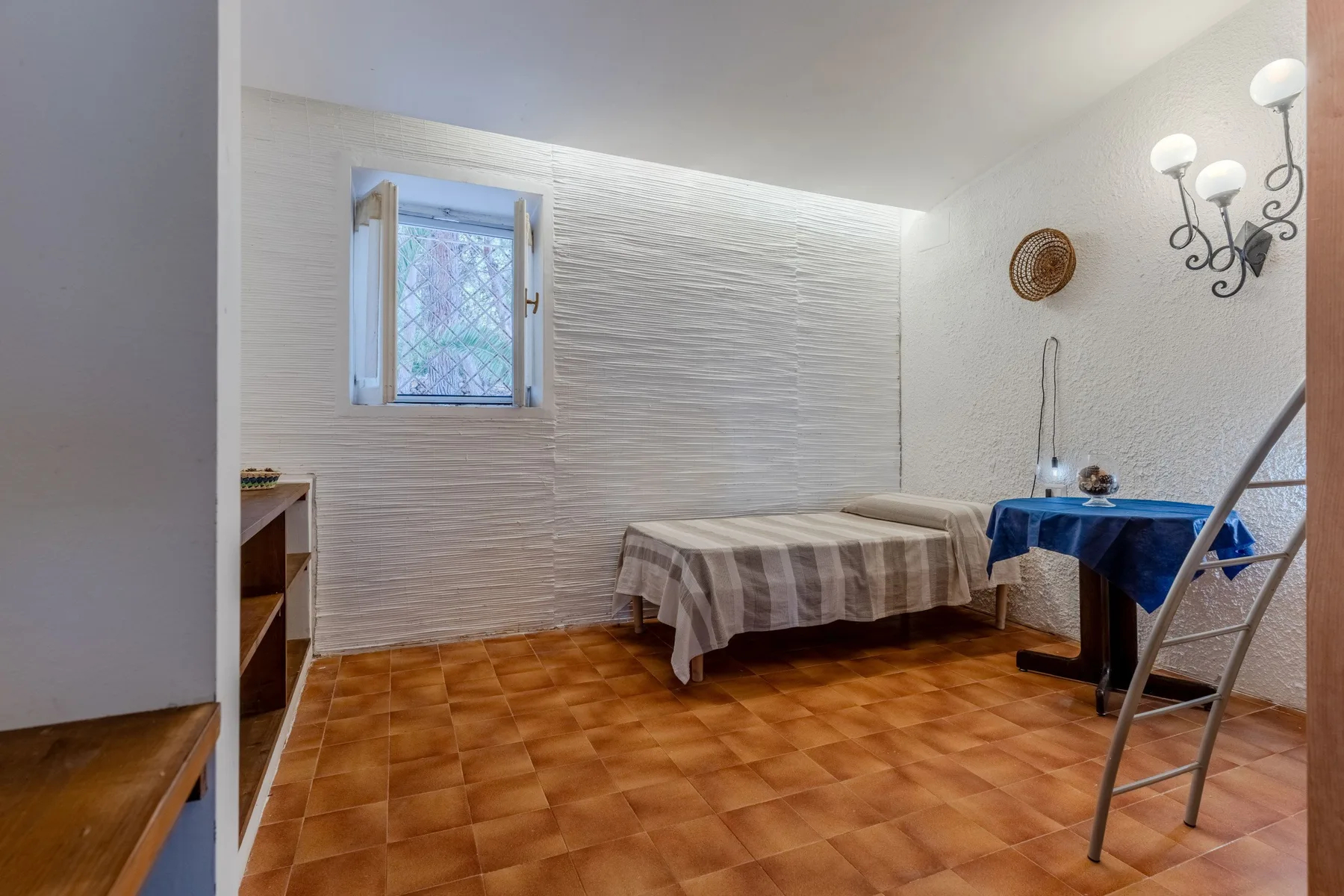 Un comedor con una mesa cubierta con un mantel a rayas y una ventana pequeña.