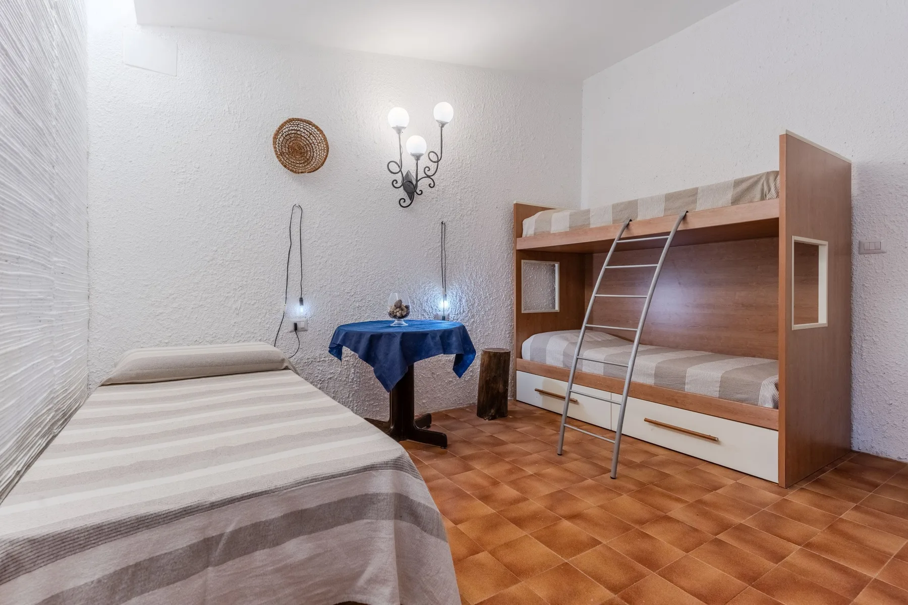 Un dormitorio con una cama individual y una litera de madera.