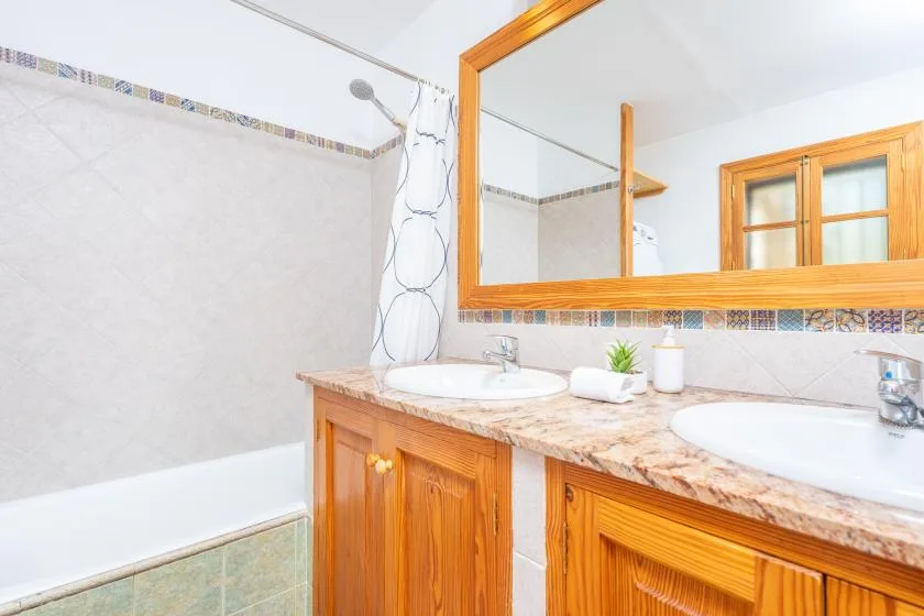 Lavabo de baño con dos lavabos y una bañera.