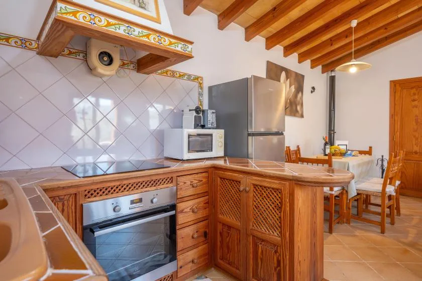 Una cocina con gabinetes de madera y una mesa de comedor.