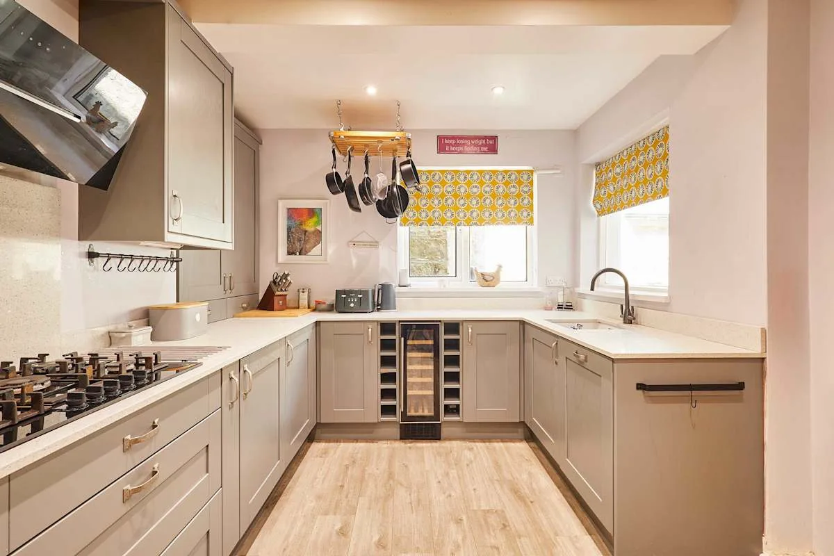 Una cocina luminosa con gabinetes claros y una zona de cocina central.