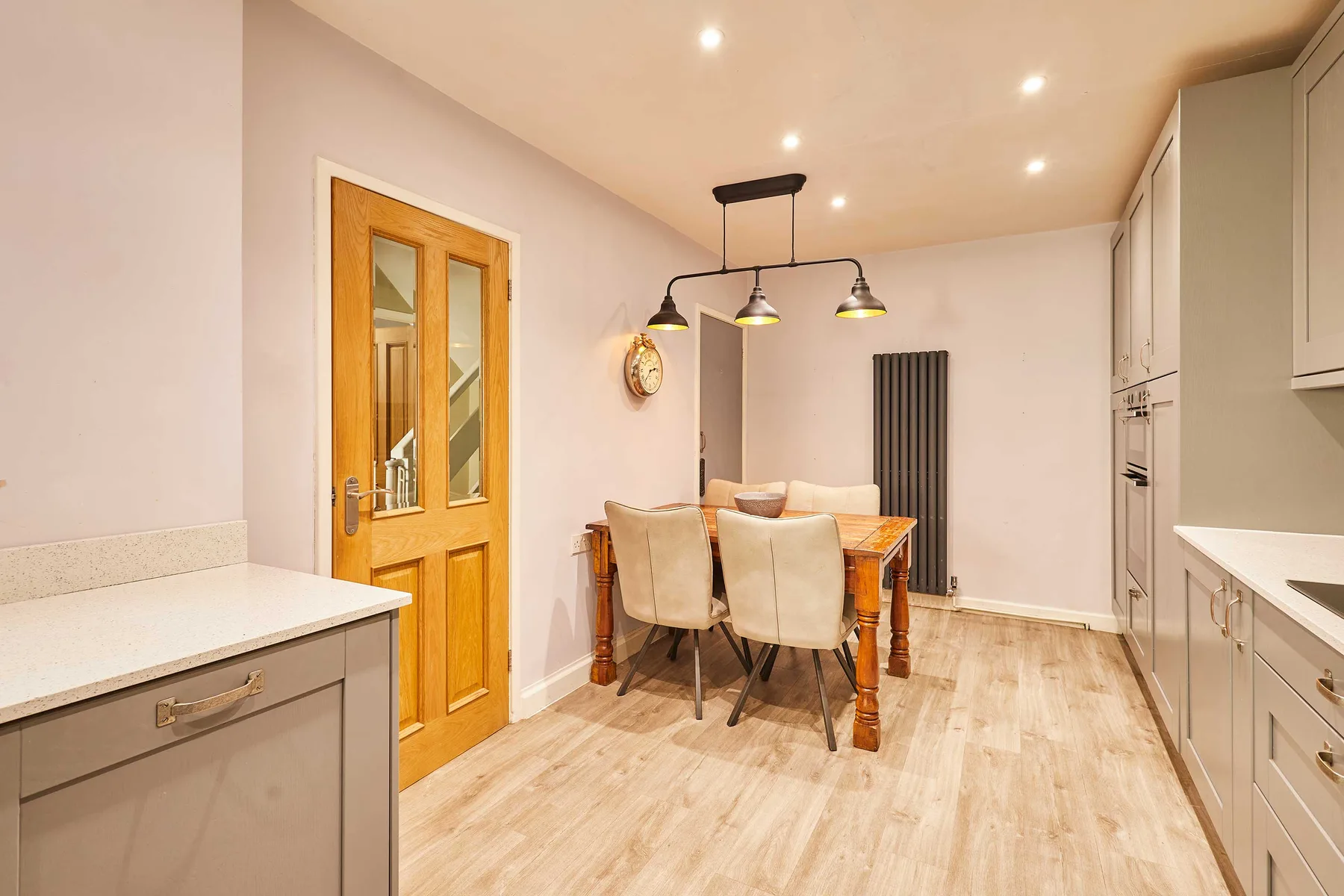Una cocina y comedor luminosos con una mesa de madera y muebles claros.