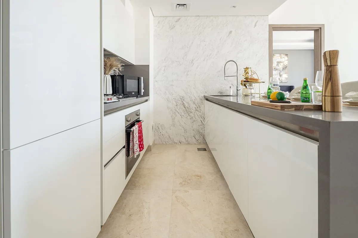 A bright modern kitchen with a long island and built-in appliances.