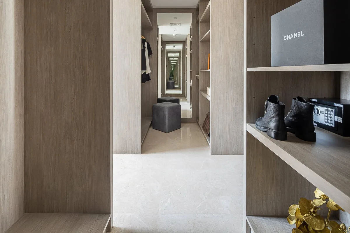 A walk-in closet with open shelving and a view down the hallway.