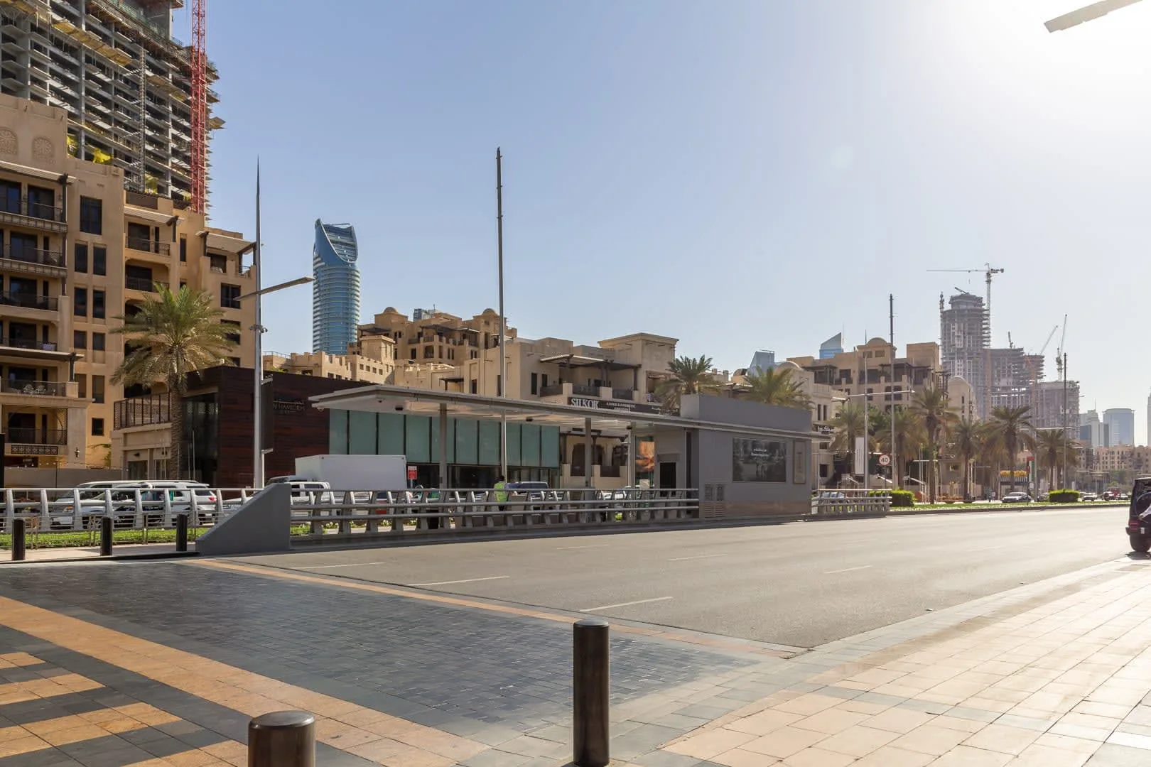 An urban street scene with modern buildings and a paved pedestrian walkway.