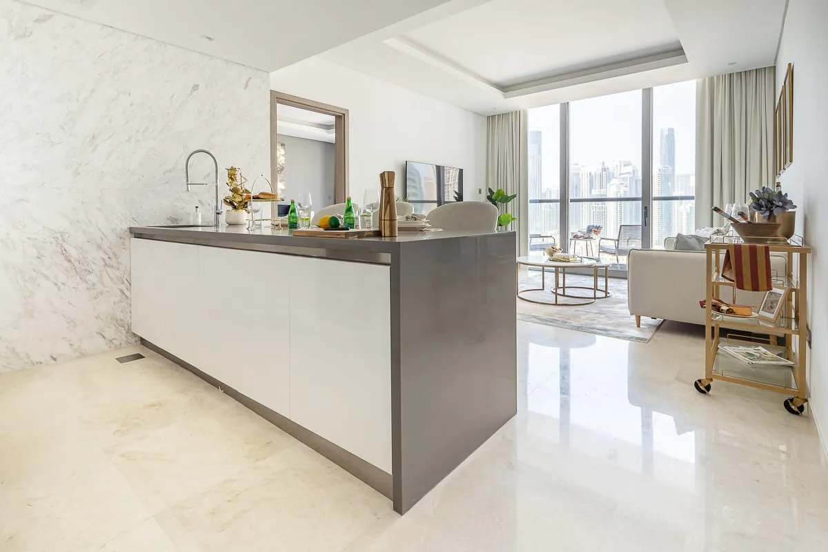 A bright open-plan kitchen and living area with large windows and contemporary furnishings.