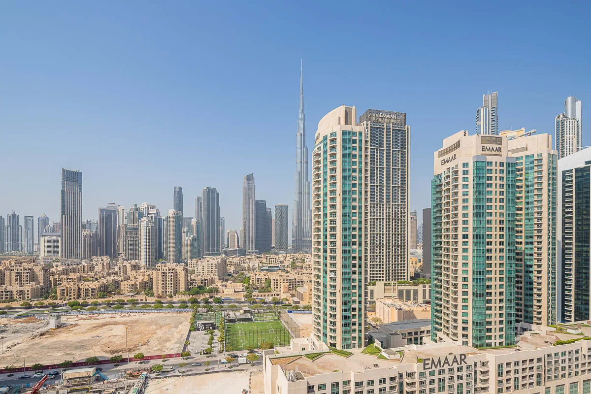 A city skyline with tall modern buildings beneath a clear blue sky.