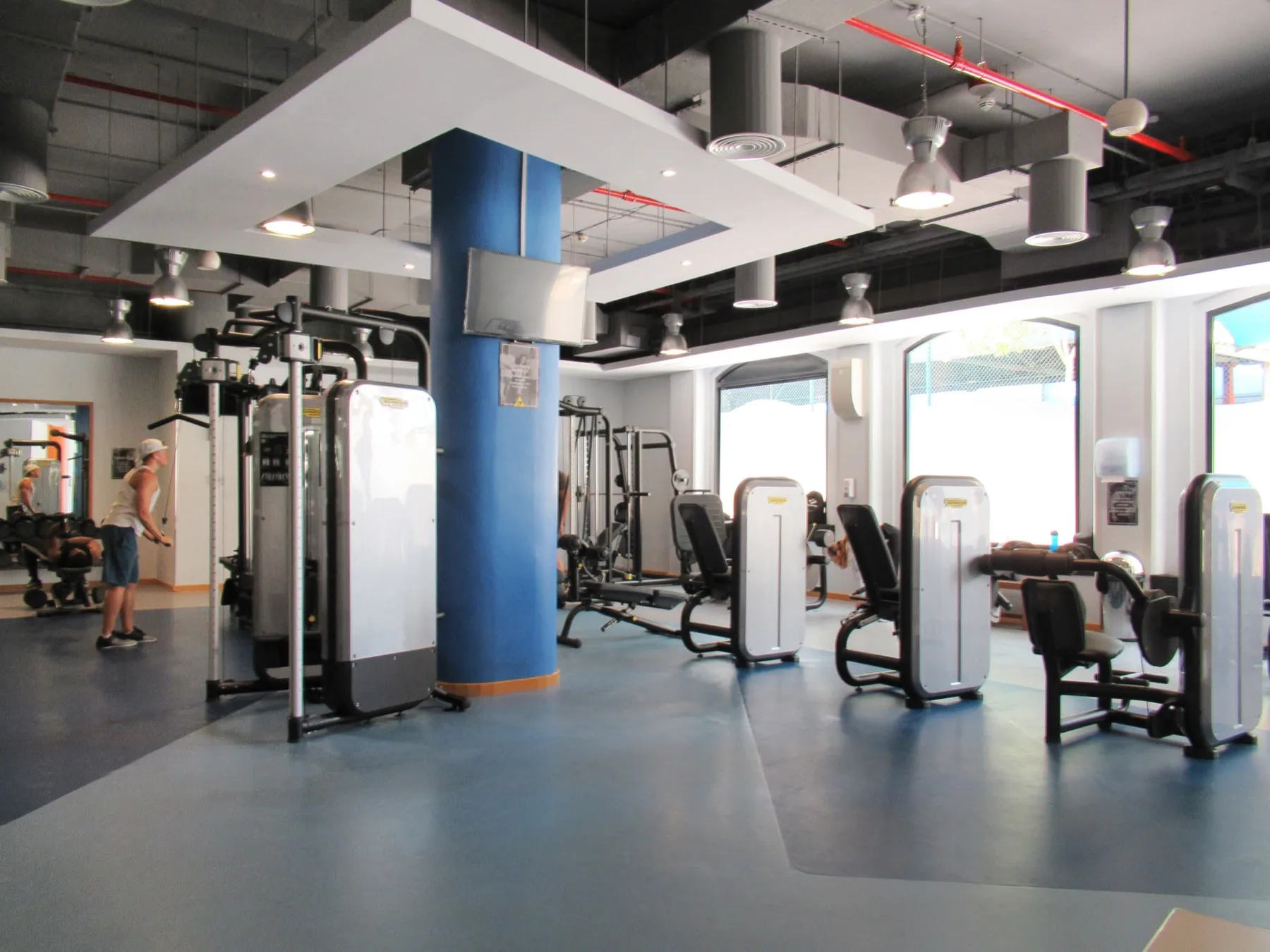 A gym with exercise machines and workout equipment.