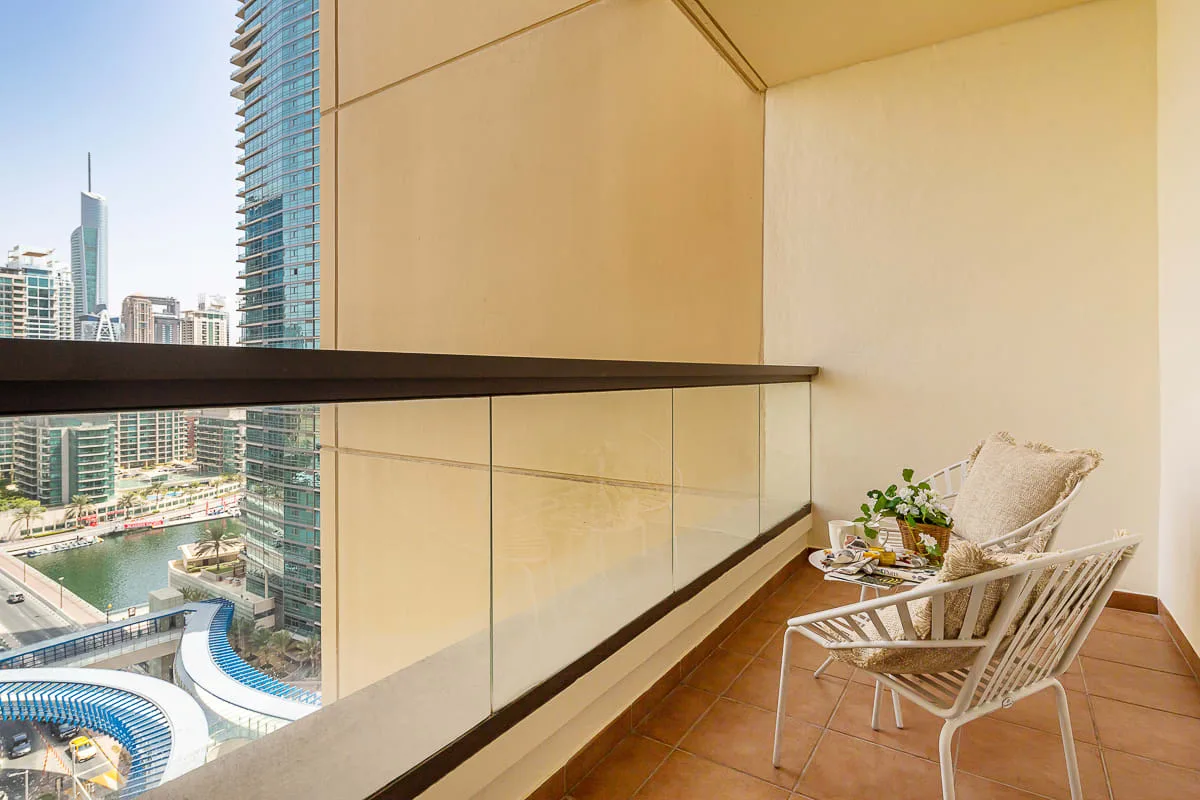 A balcony seating area overlooks a city skyline and a curving pool.