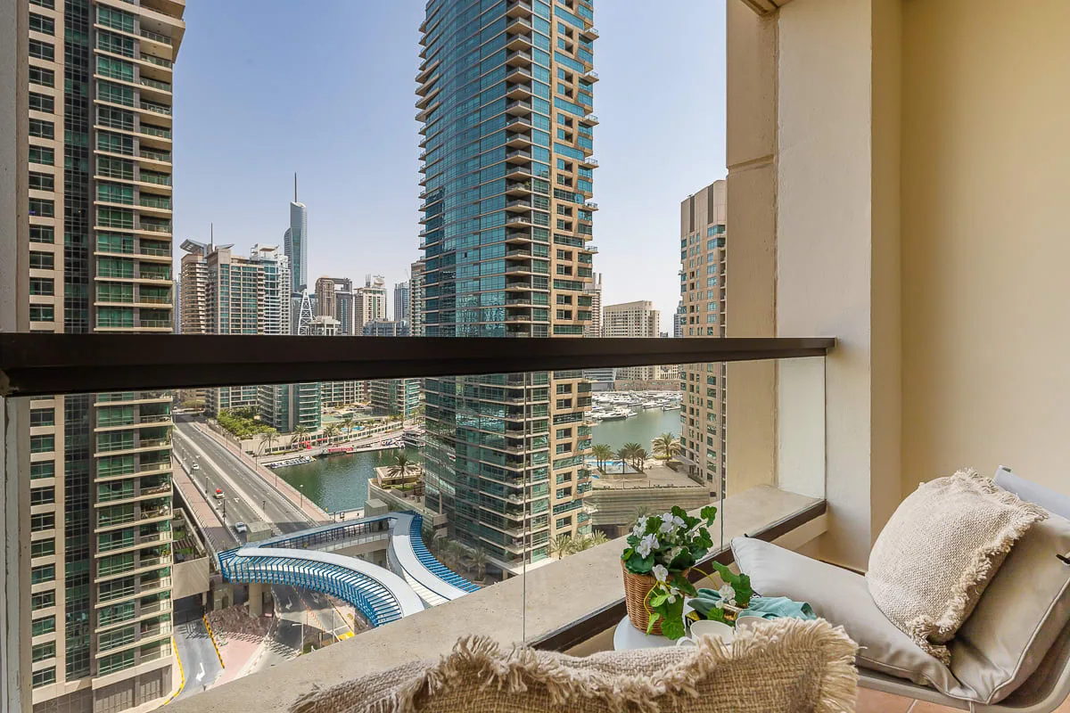 A high-rise seating area overlooks a cluster of towers and a canal.