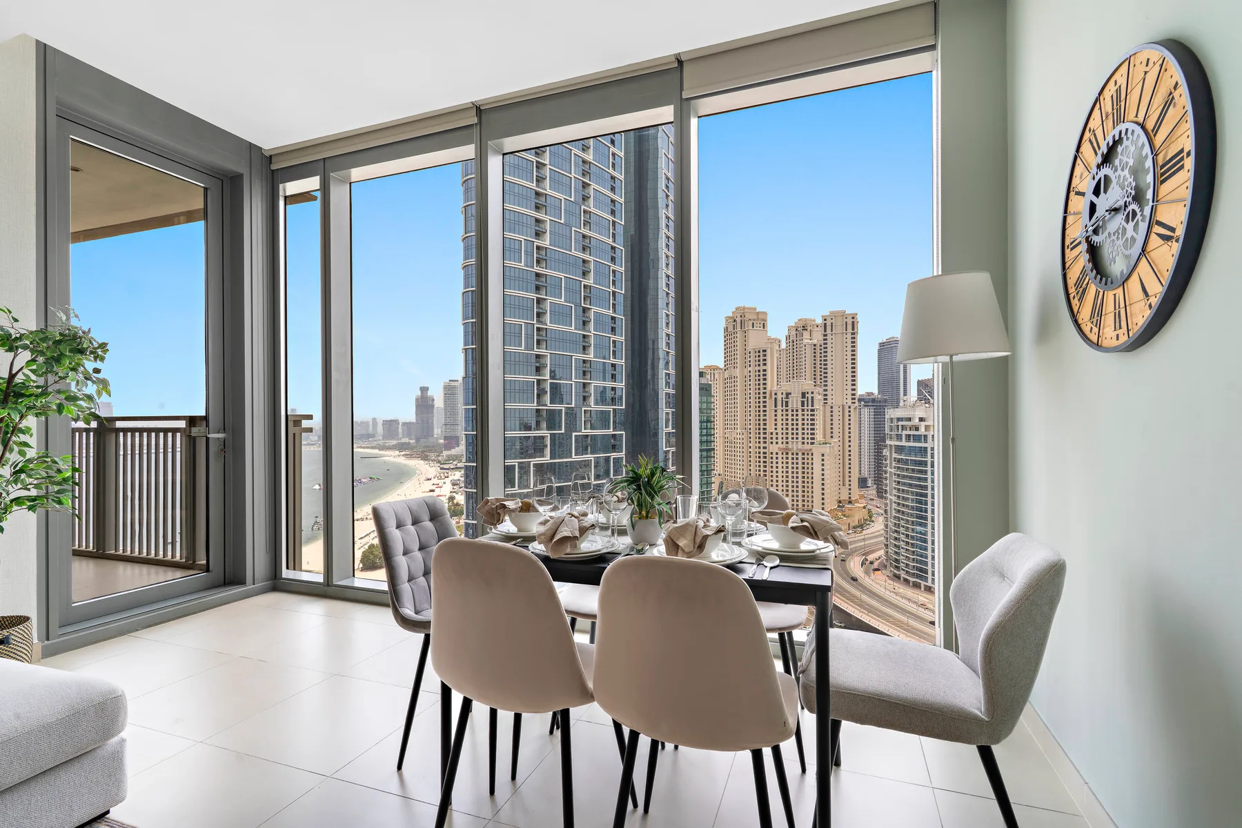 Un comedor luminoso con una mesa junto a grandes ventanas con vistas a edificios de la ciudad.