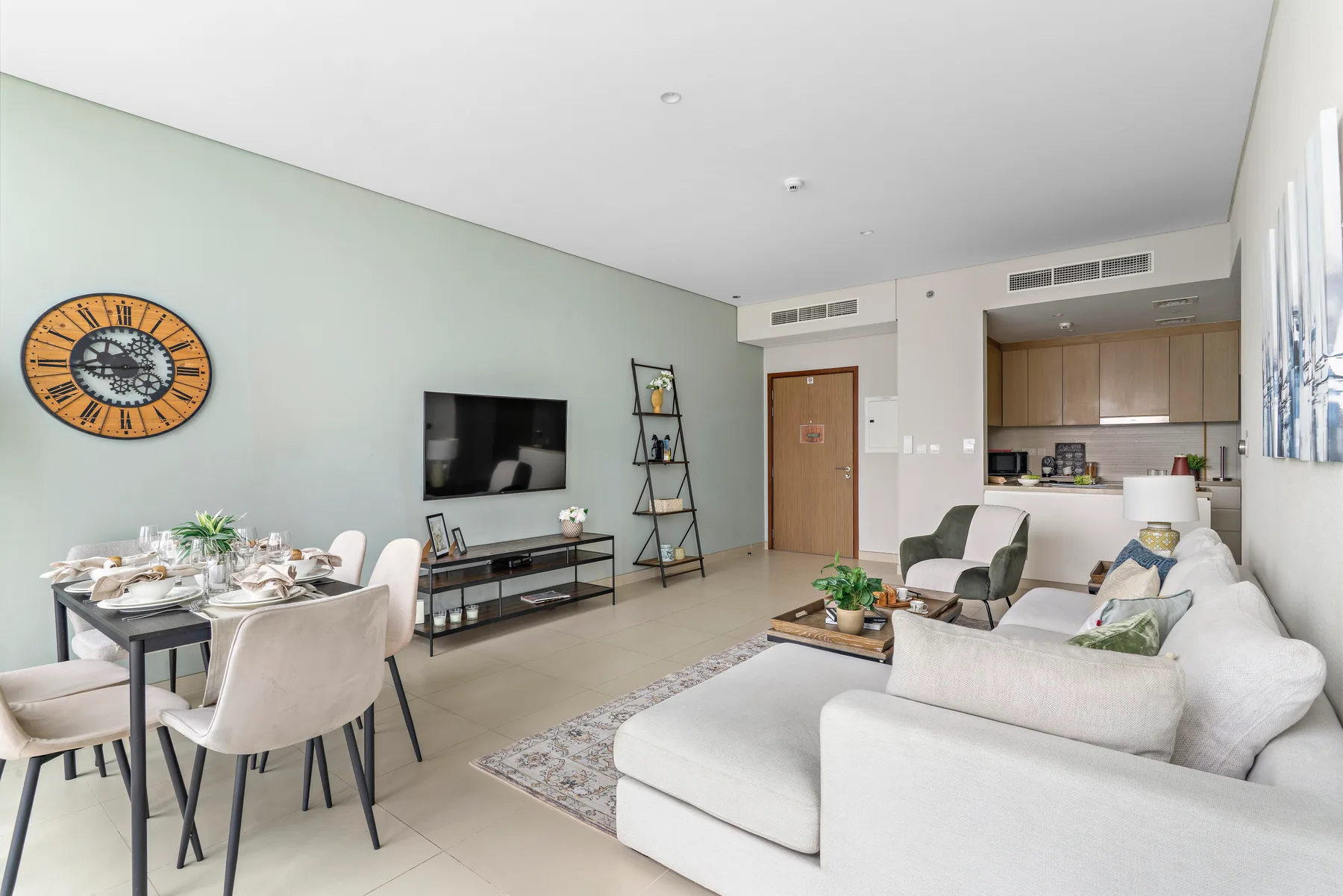 Una luminosa sala de estar y comedor con televisión, asientos y una mesa de comedor.