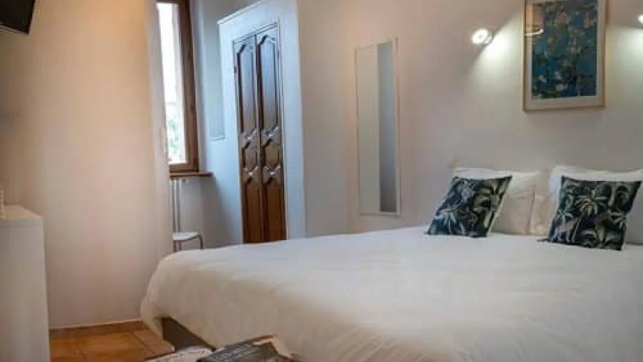 Bright room with a double bed and modern decor.