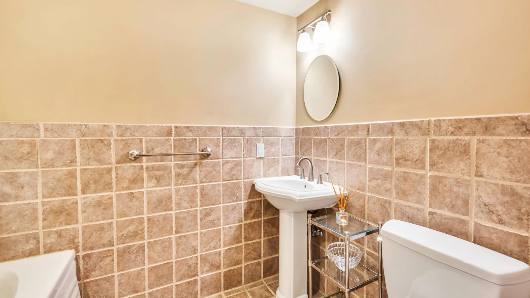 Un baño con lavabo, espejo e inodoro.