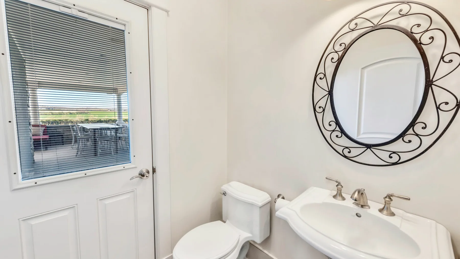 Un lavabo de baño está junto a una puerta con ventana.