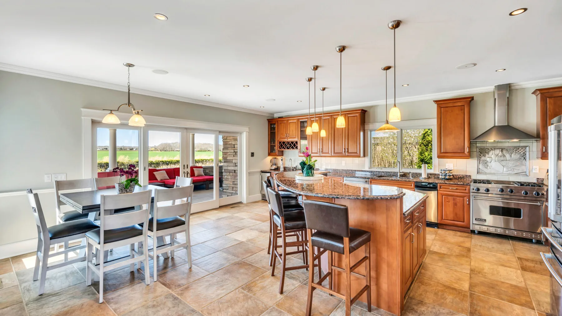 Una cocina y comedor luminosos con una isla de madera y una mesa.