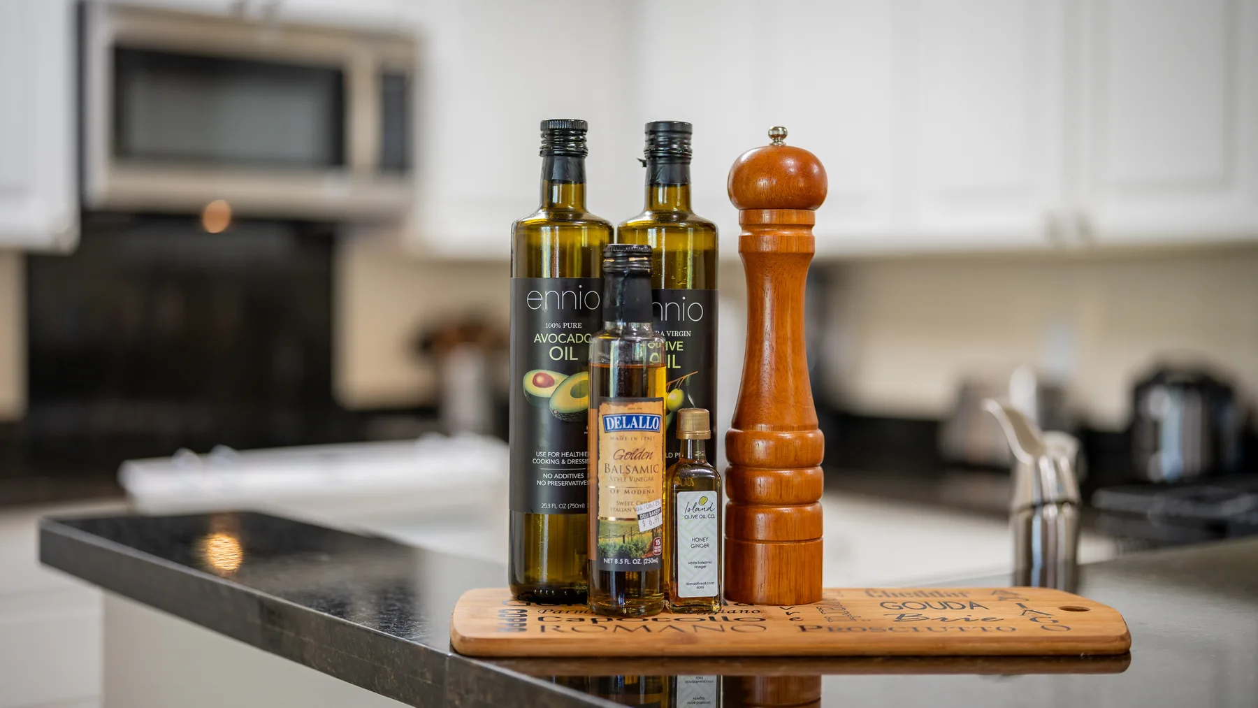 A kitchen island displays bottles of oil and a wooden pepper mill.
