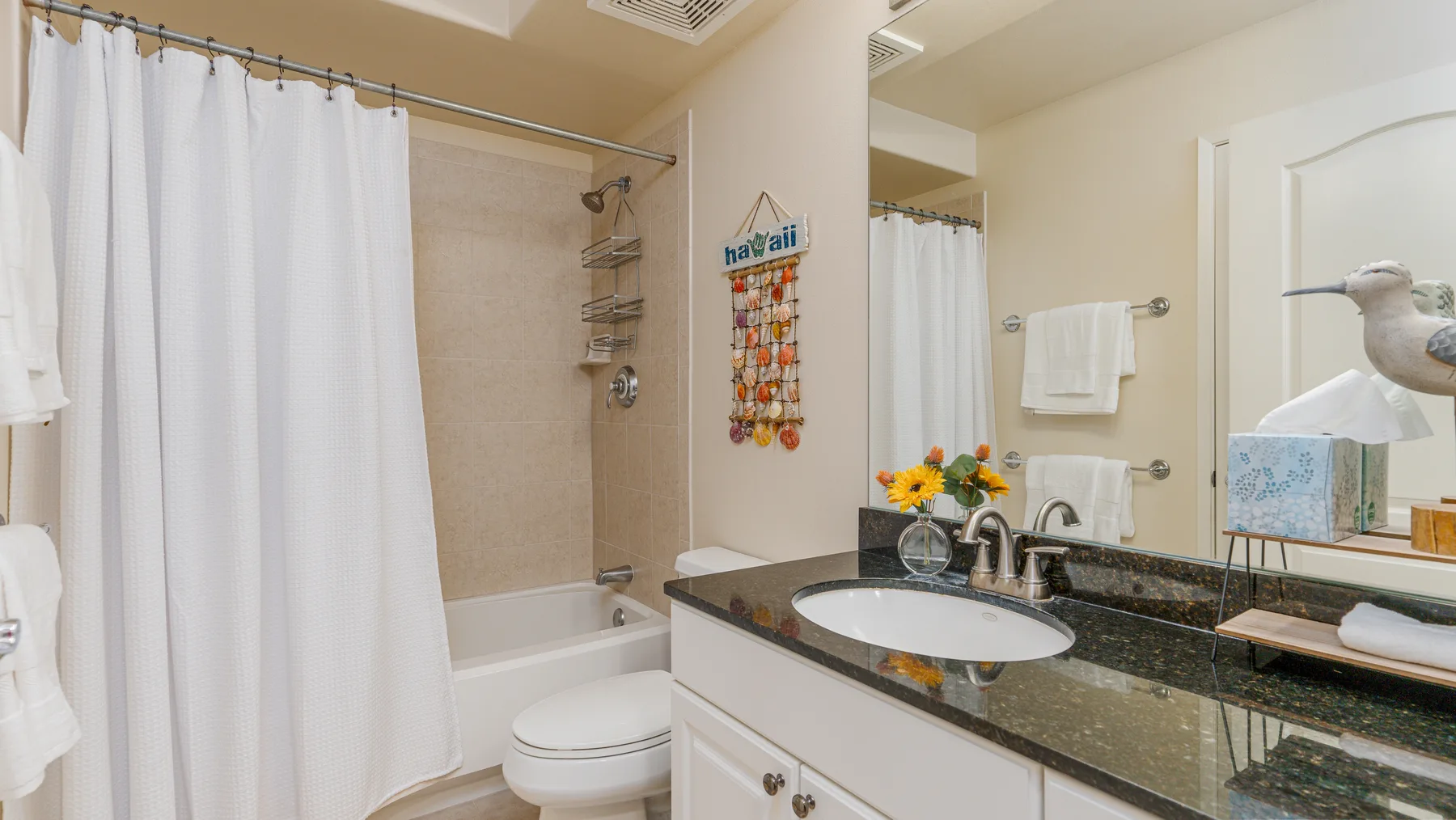 A bathroom with a bathtub, shower curtain, and sink.