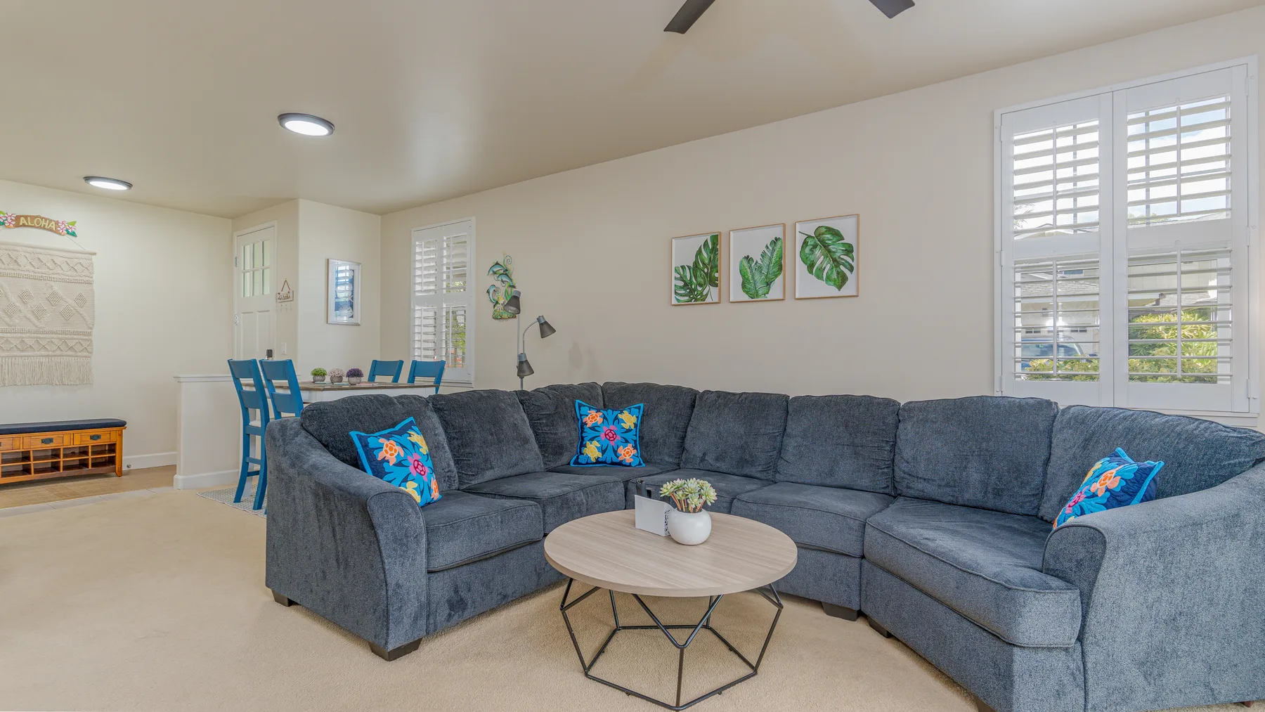 A living room with a large sectional seating area and round coffee table.