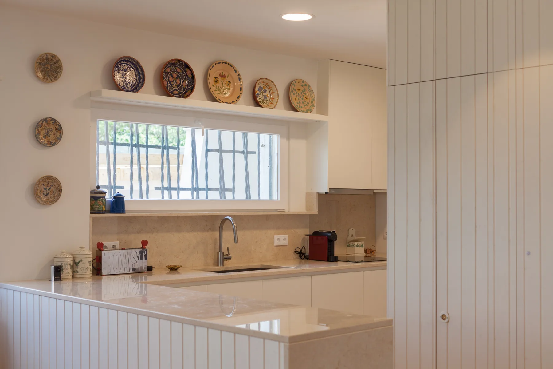 Una cocina luminosa con encimera, fregadero y ventana.