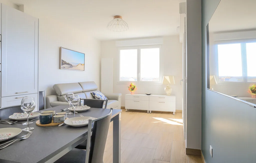 A bright living and dining area with a sofa and a set dining table.