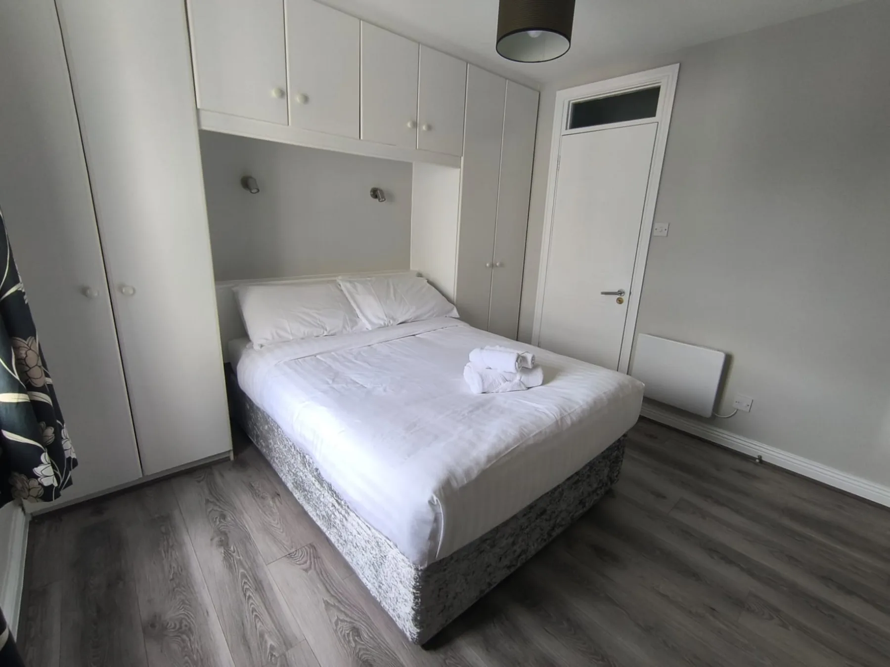 Dormitorio con una cama bajo armarios empotrados.