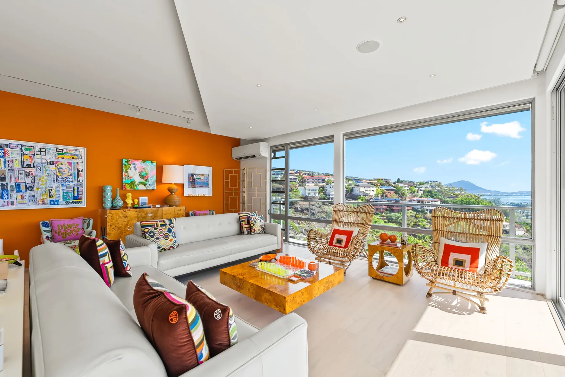 A bright living room with seating and large windows overlooking the surrounding landscape.