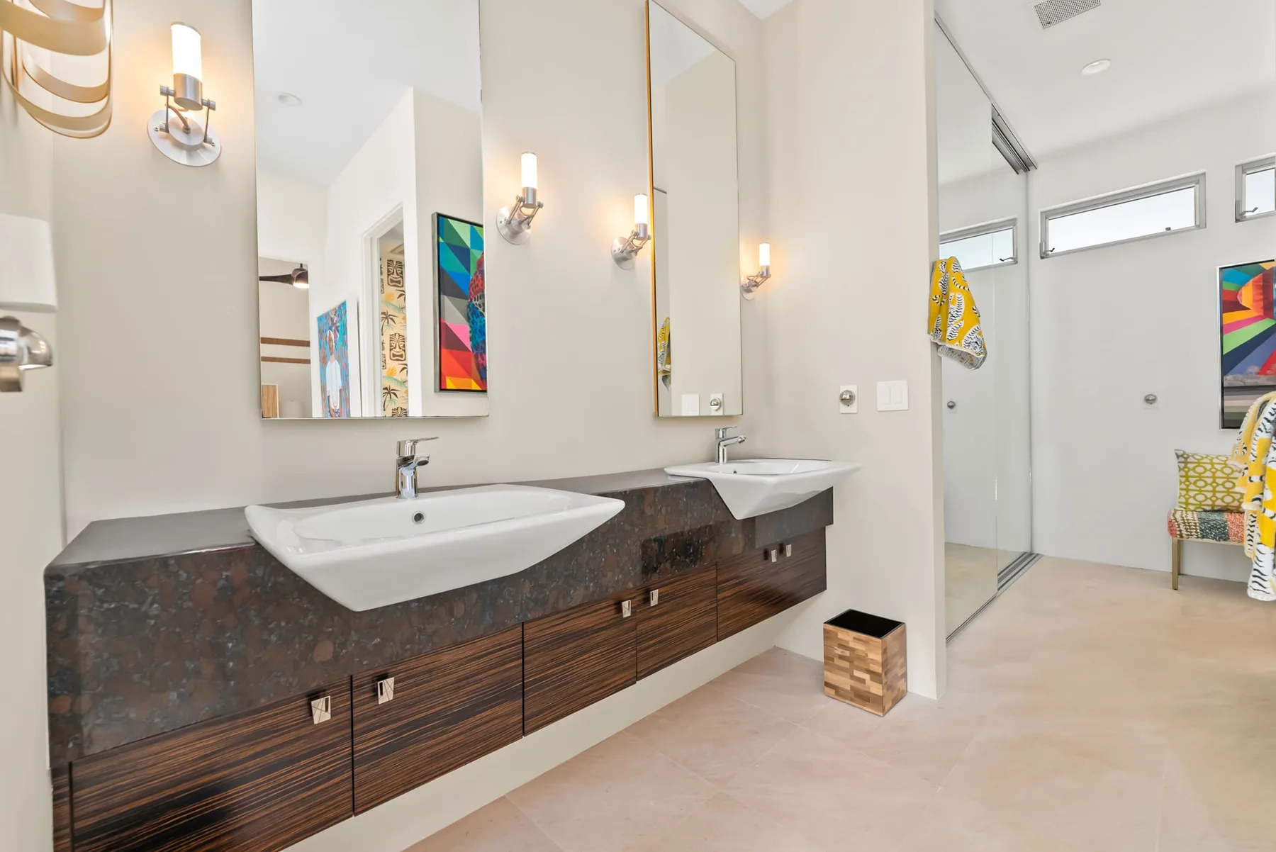 A bright bathroom with two sinks, long counters, and large mirrors.