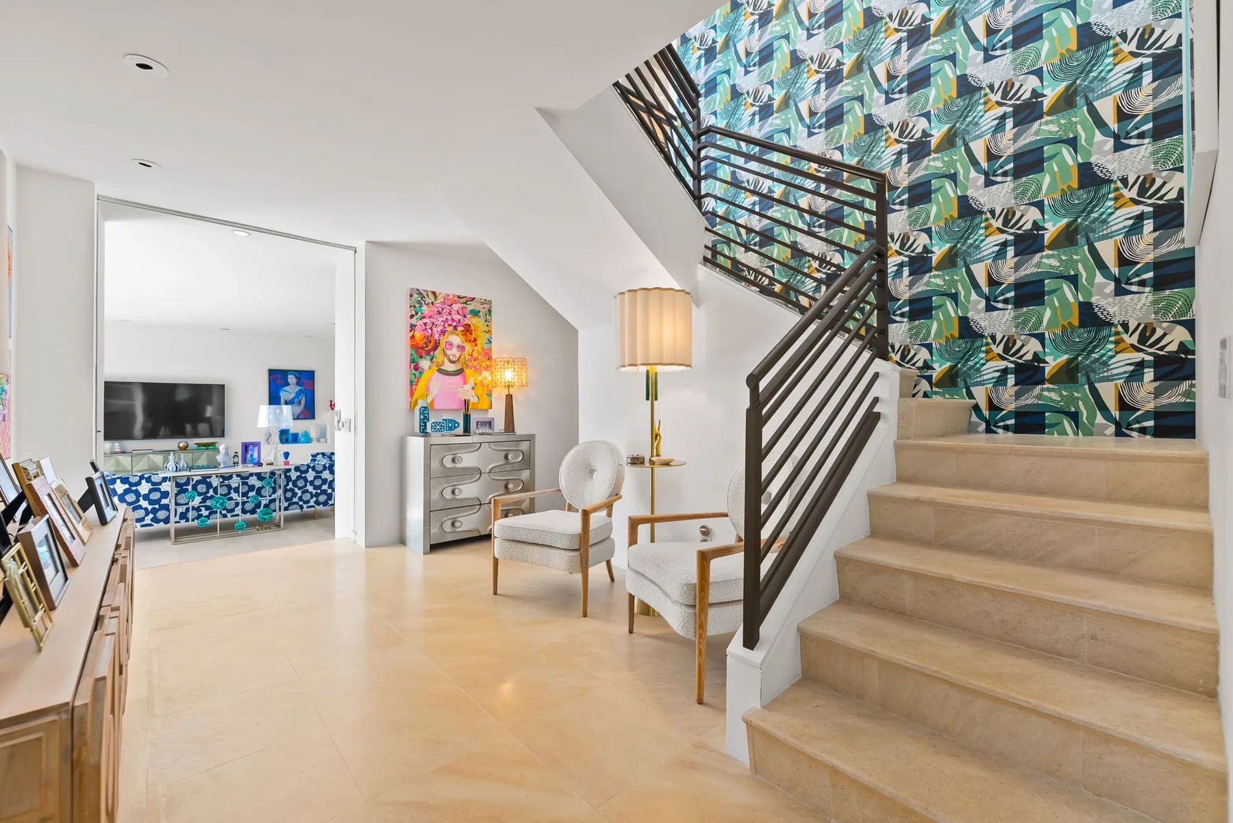 A bright living area opens beside a staircase with a patterned wall.