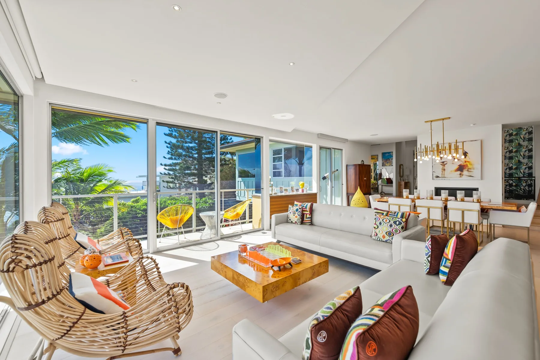 A bright living and dining area opens onto a balcony through large windows.