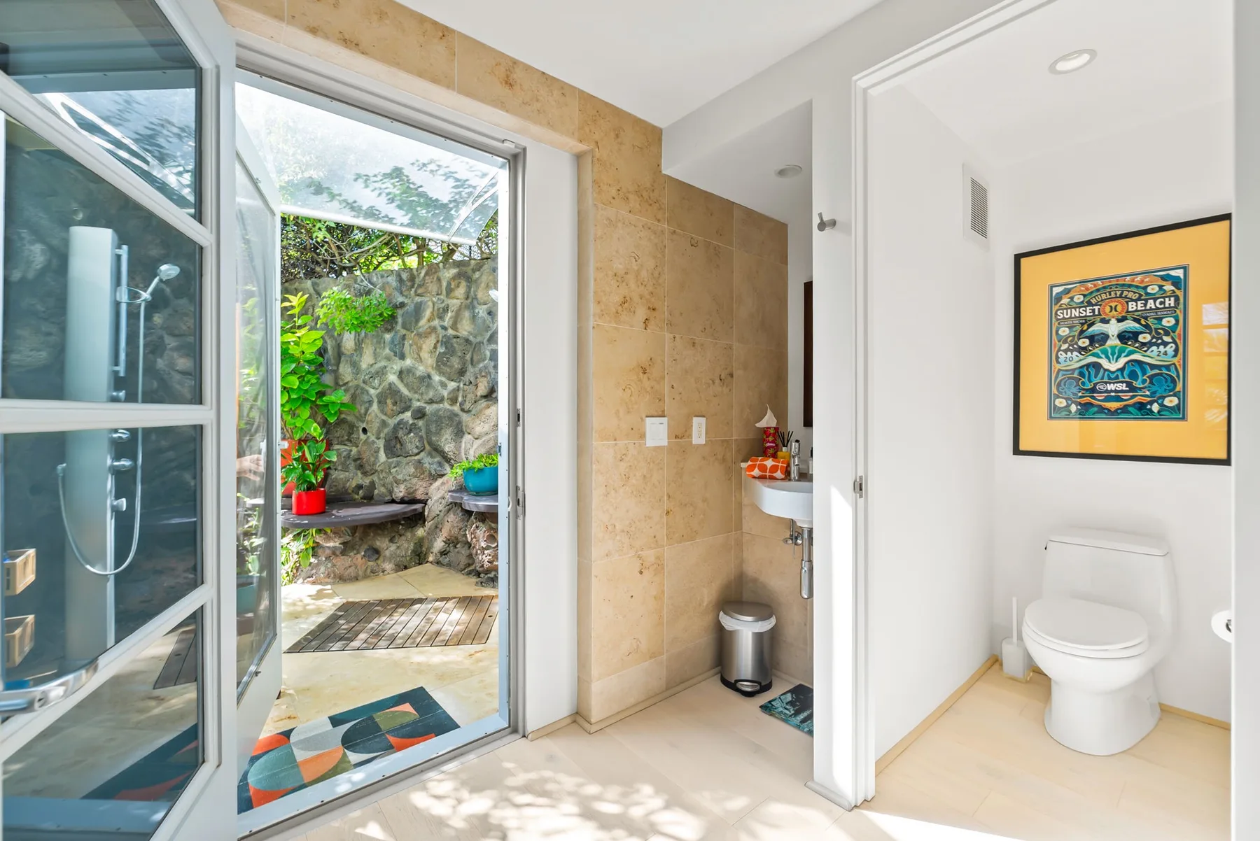 A bathroom opens onto a small patio, with a toilet visible in the adjoining space.