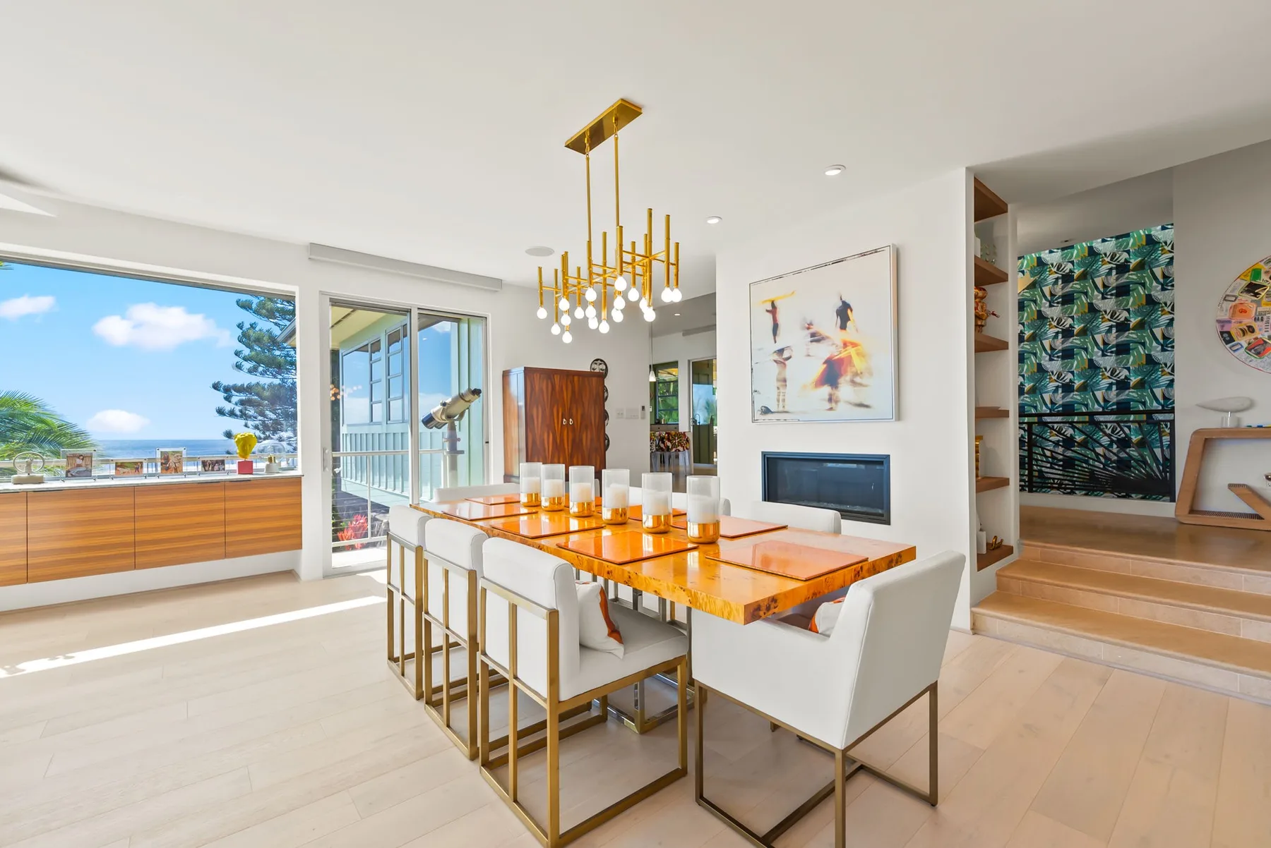 A bright dining area with a long table beside large windows.