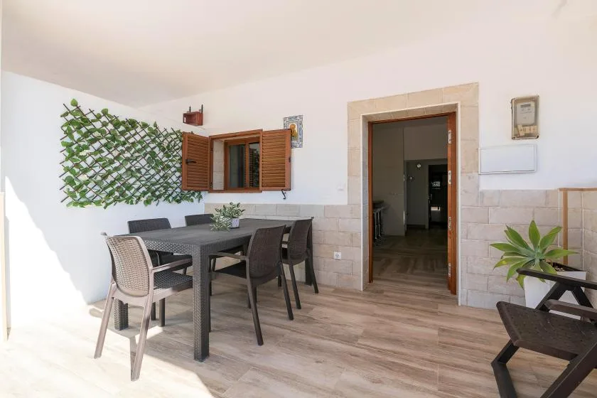A dining area with a table and chairs beside an open doorway.