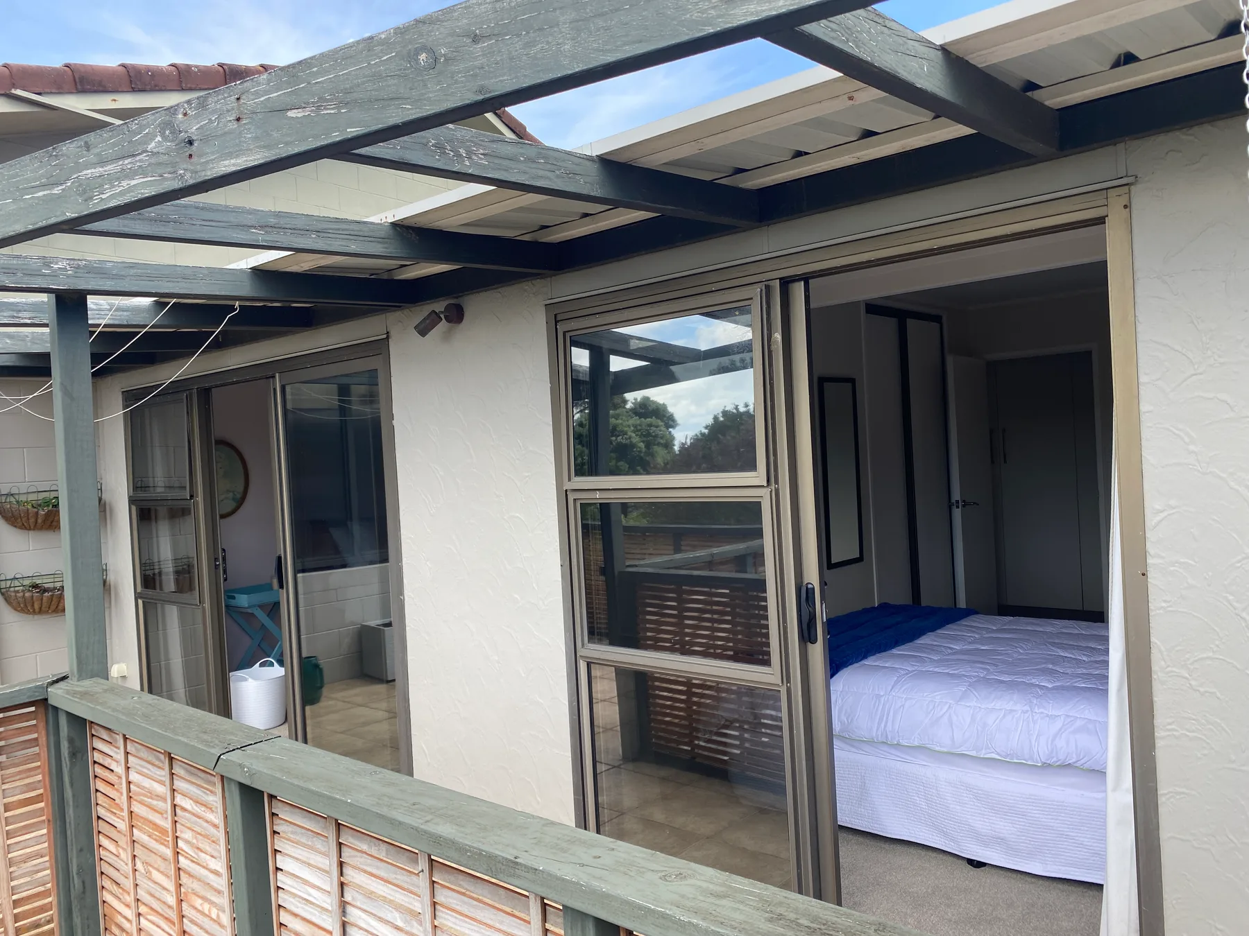 Un dormitorio se abre a un patio exterior cubierto.