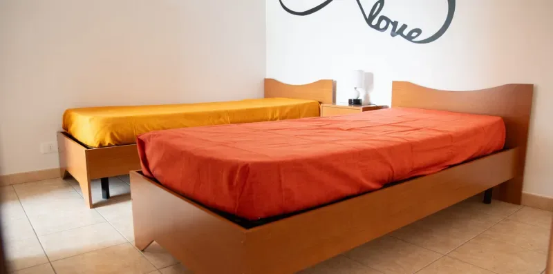 Un dormitorio con una cama grande cubierta con ropa de cama naranja.