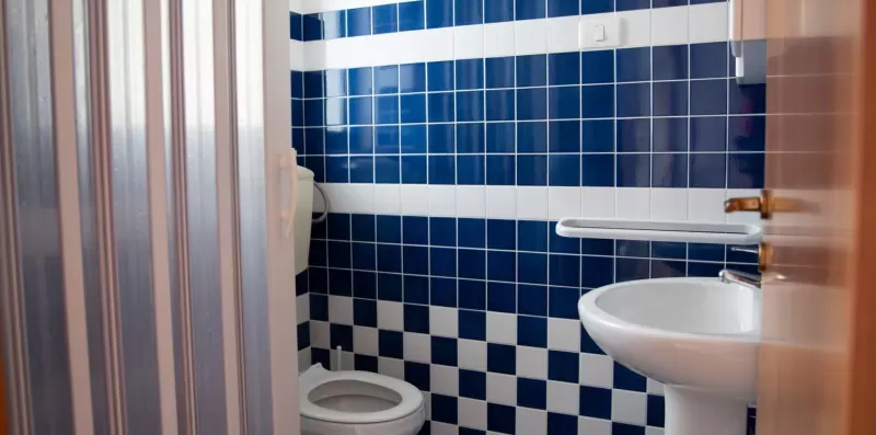 Un baño alicatado con un inodoro y un lavabo con pedestal.