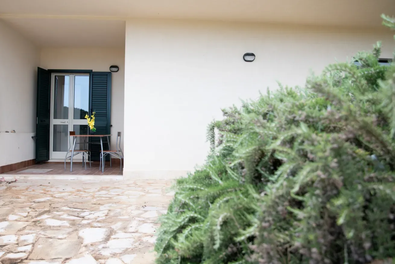 Un patio con pavimento de piedra y una mesa junto a una puerta abierta.