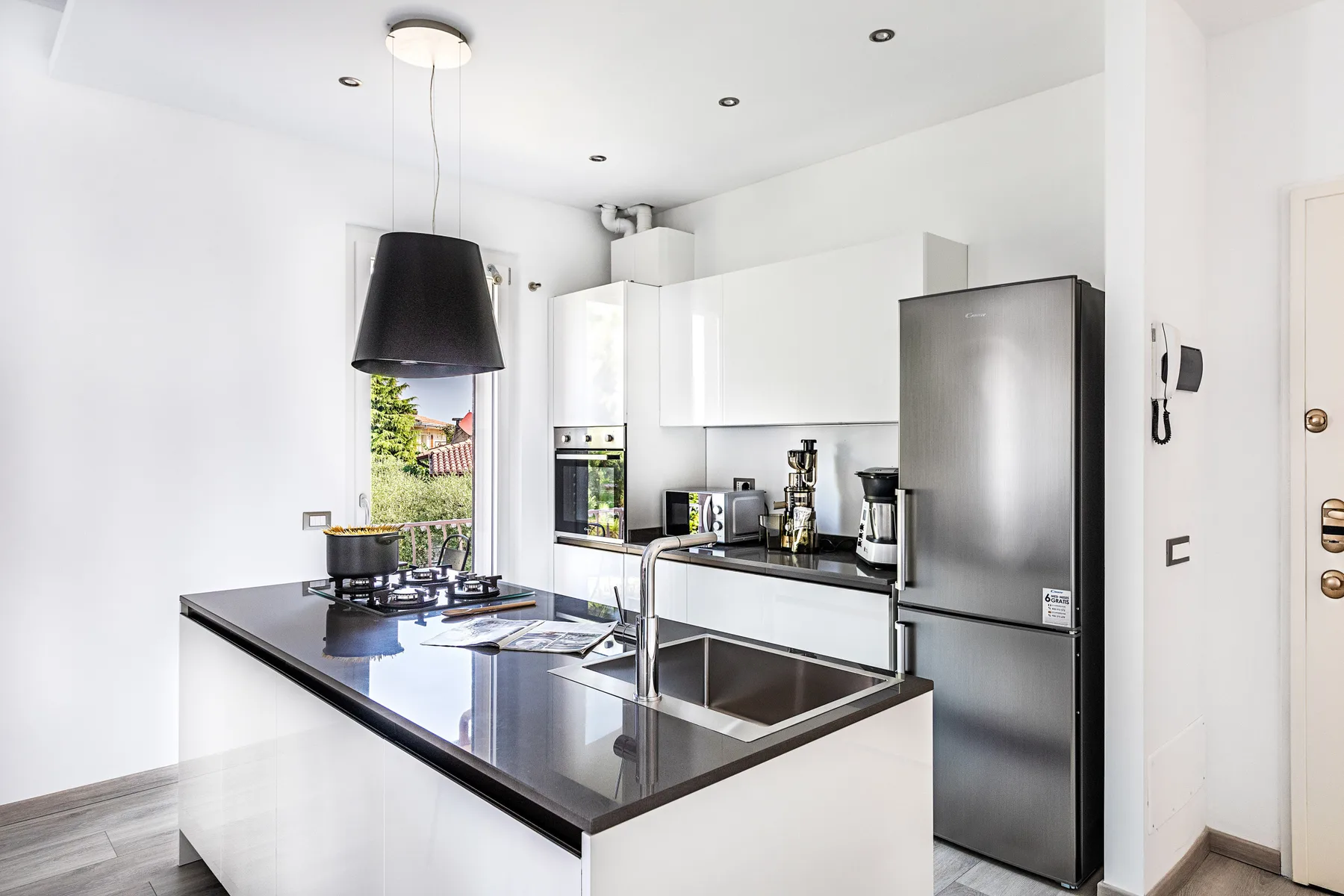A bright kitchen with a central island, sink, and stainless steel appliances.