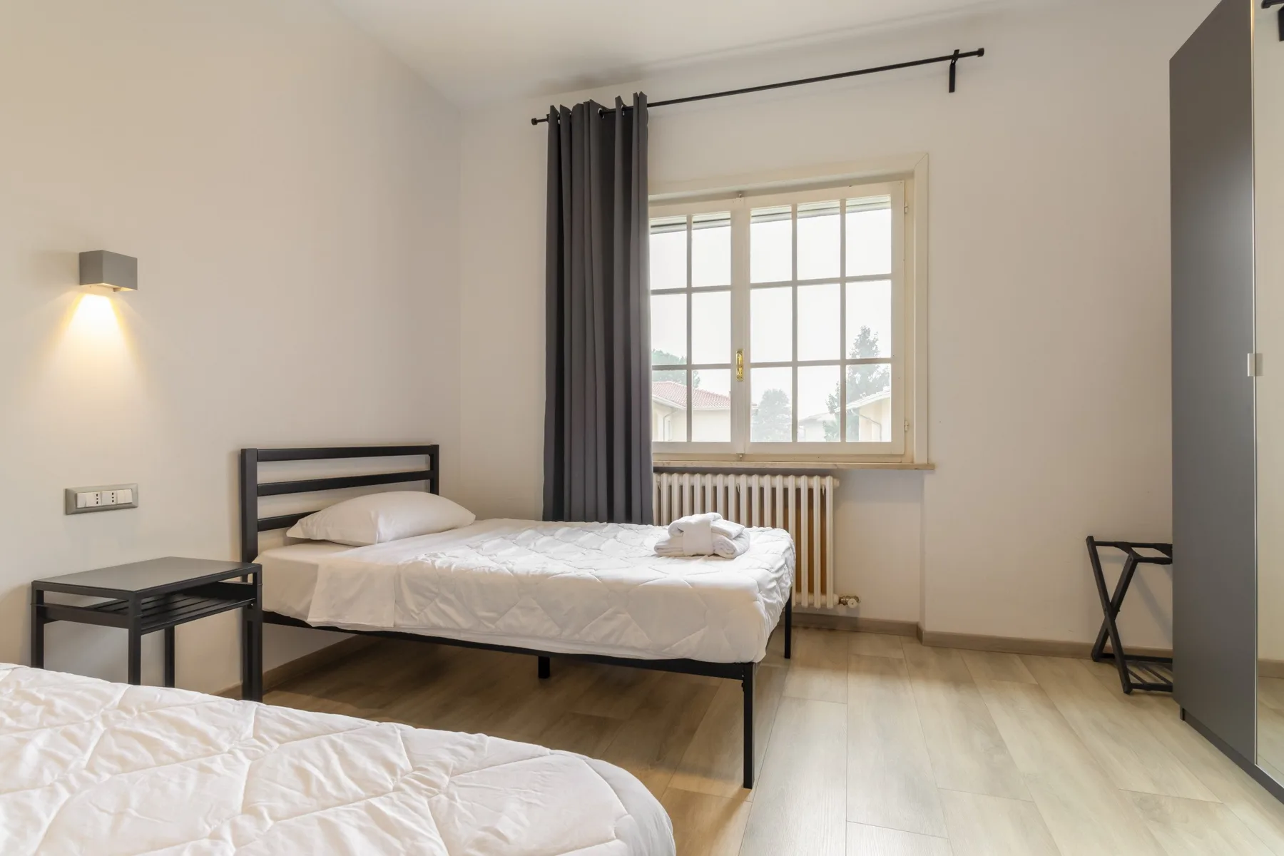 A bedroom with a single bed beside a window and radiator.