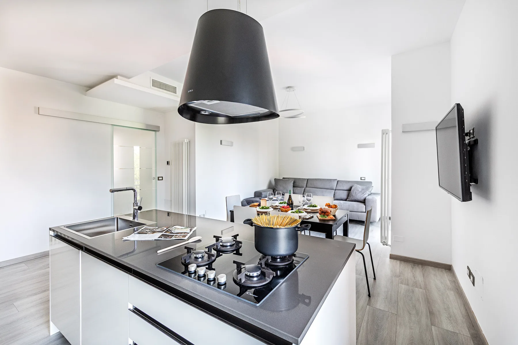 A bright open-plan kitchen and living area with a cooking island and seating.