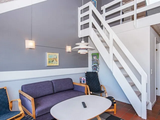 A living area with seating, a coffee table, and a staircase.