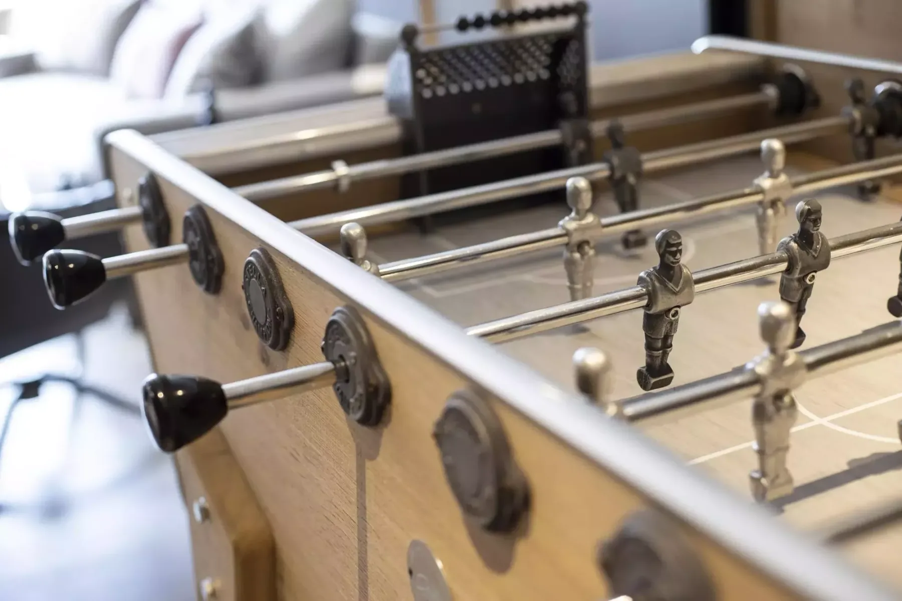 A foosball table with rows of player figures fills the foreground.