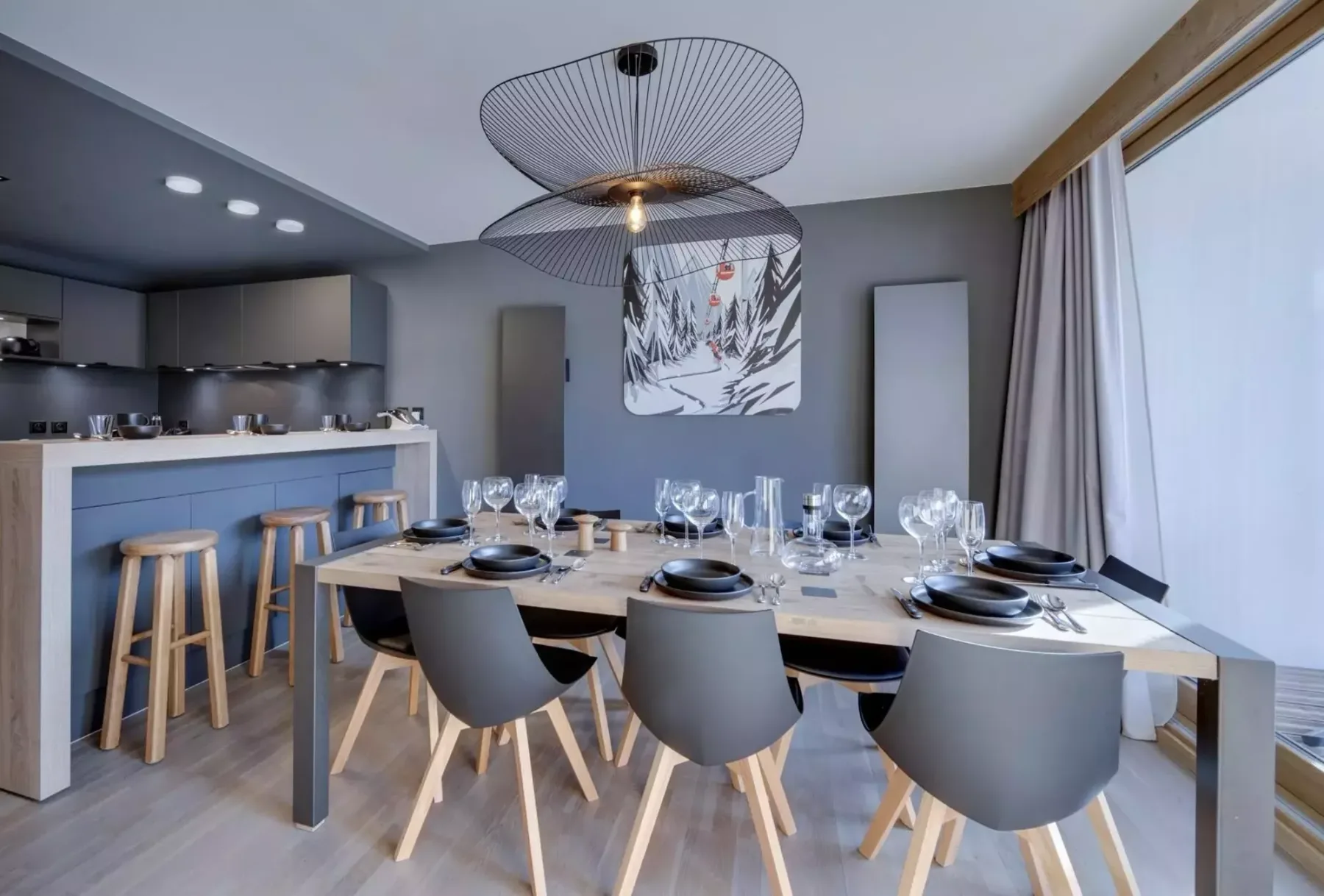 A dining area with a set table and a kitchen counter behind it.