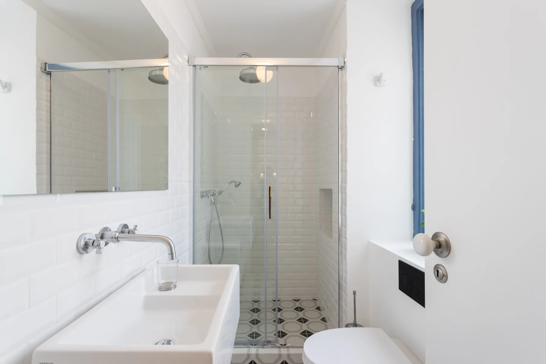 Un baño luminoso con lavabo y ducha de vidrio.