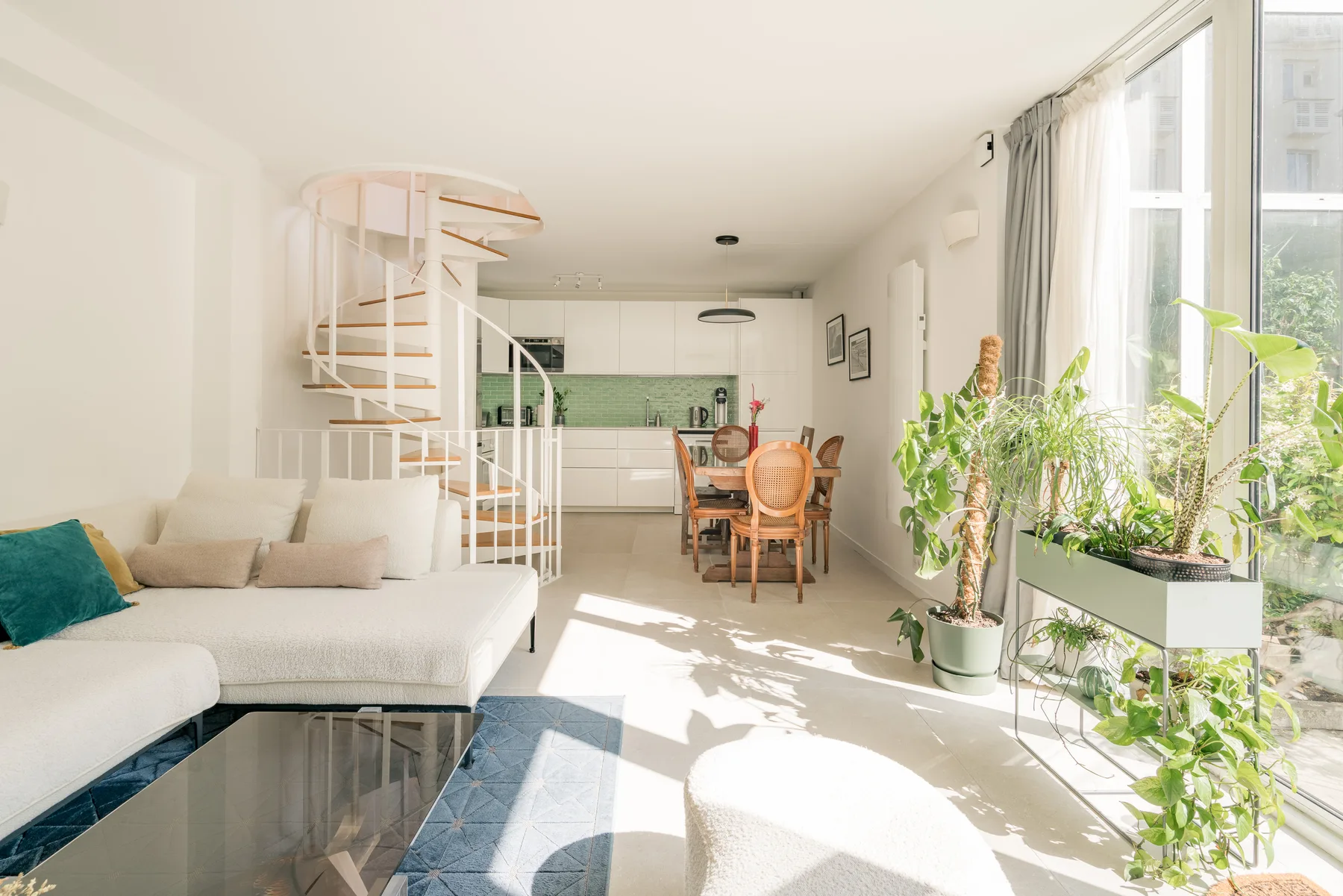 A bright open-plan living and dining area with a kitchen at the back.