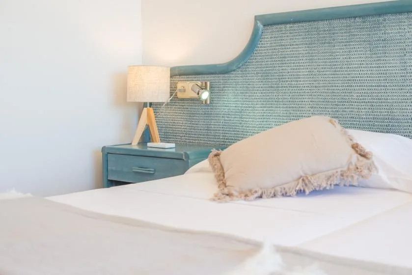 Bedroom with a bed, blue upholstered headboard, and bedside table.