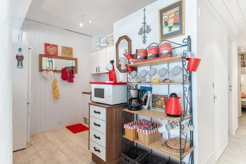 Una cocina luminosa con un microondas y estantes abiertos con platos y pequeños electrodomésticos.