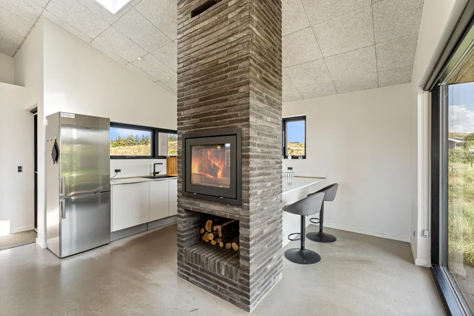 Una cocina abierta y zona de comedor con una chimenea de ladrillo.